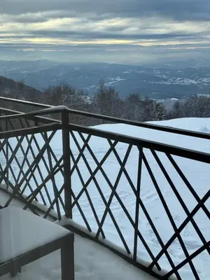 a snow covered balcony with a bench in the snow at Grand Elegant & Spa Kop in Kopaonik