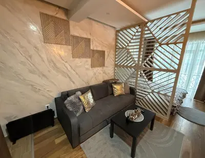 a living room with a couch and a wooden wall at Grand Elegant & Spa Kop in Kopaonik