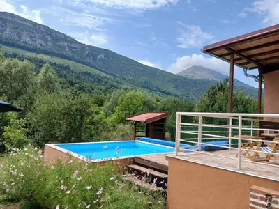 a house with a swimming pool with mountains in the background at Vikendica Lep pogled in Rtanj