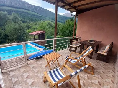 a patio with chairs and a table and a pool at Vikendica Lep pogled in Rtanj