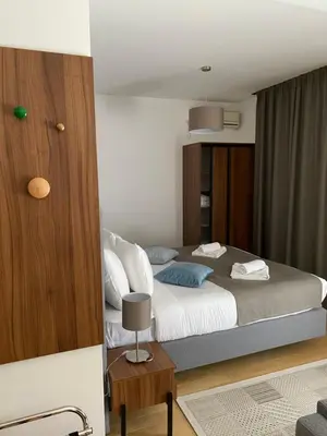 a bedroom with a large bed and a table at MILA in Vrnjačka Banja