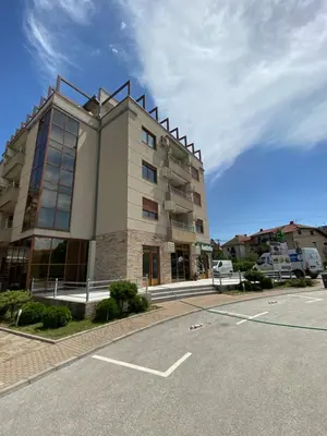 a building with a parking lot in front of it at MILA in Vrnjačka Banja