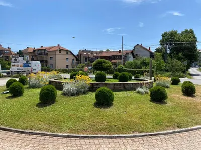 a garden with bushes and trees in a city at MILA in Vrnjačka Banja