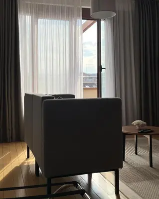 a living room with a tv and a table and a window at MILA in Vrnjačka Banja