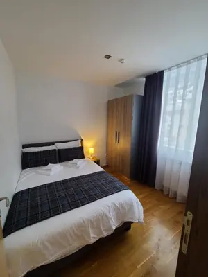 a bedroom with a large bed and large windows at BELI VUK - Brzeće, Kopaonik in Brzeće