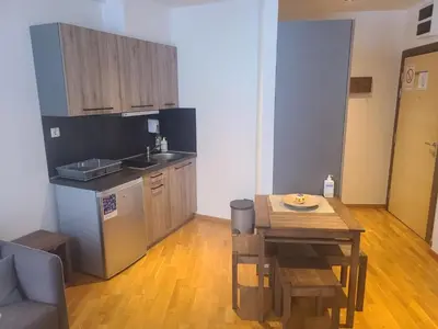 a kitchen with a table and a small table and a table and a kitchen with at BELI VUK - Brzeće, Kopaonik in Brzeće