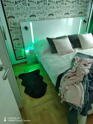 a bedroom with a bed and a rug on the floor at Apartman Safir in Vrnjačka Banja