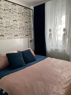 a bedroom with a large bed and a window at Apartman Safir in Vrnjačka Banja