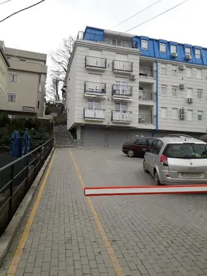 a car parked in a parking lot in front of a building at Apartman Safir in Vrnjačka Banja