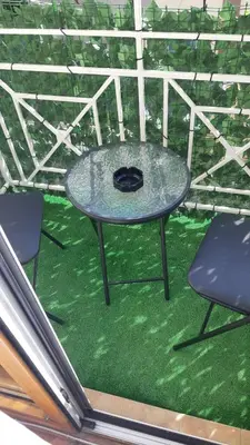 a table and two chairs on a patio with grass at Apartman JELENA M Vrnjačka Banja in Vrnjačka Banja