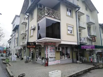 a building on a street with shops on it at Apartman JELENA M Vrnjačka Banja in Vrnjačka Banja