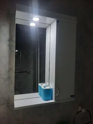 a bathroom sink with a mirror and a blue basket at Apartman JELENA M Vrnjačka Banja in Vrnjačka Banja