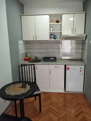 a small kitchen with a table and a refrigerator at Apartman JELENA M Vrnjačka Banja in Vrnjačka Banja