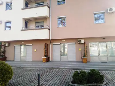a building with doors and windows on a street at Apartman NIKOLIJA Vrnjačka Banja in Vrnjačka Banja