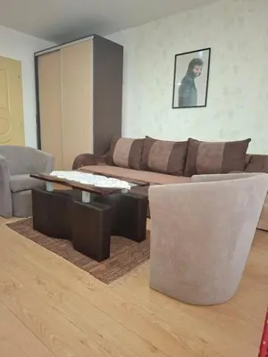 a living room with a couch and a table and chairs at Apartman NIKOLIJA Vrnjačka Banja in Vrnjačka Banja