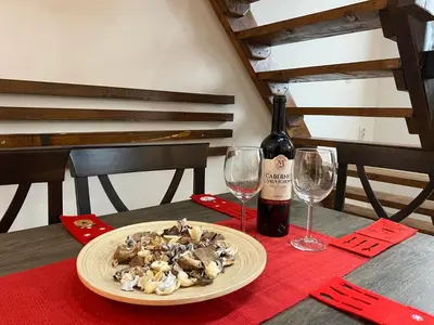 a plate of mushrooms and a bottle of wine on a table at Apartmani Vidatela Kopaonik in Kopaonik