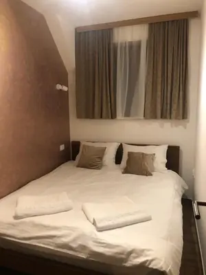 a large white bed with two pillows and a mirror at Apartmani Vidatela Kopaonik in Kopaonik