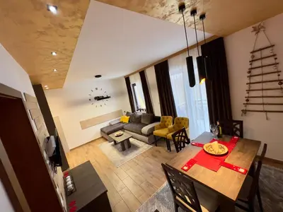 a living room with a table and a couch at Apartmani Vidatela Kopaonik in Kopaonik