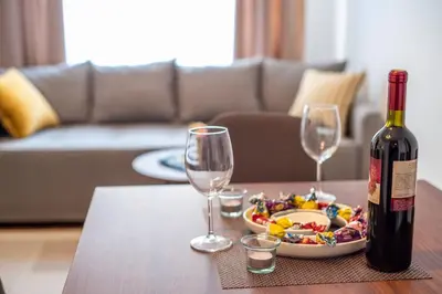 a bottle of wine and two glasses on a table at Apartman EROS in Vrnjačka Banja