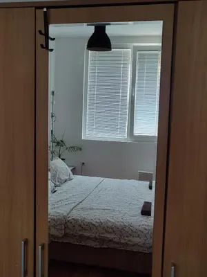 a bedroom with a bed and two windows at Apartman Aleksic in Niš