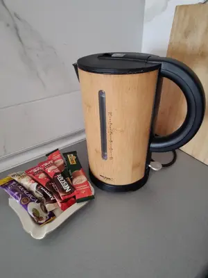 a coffee cup sitting on a table next to a magazine at Apartman Aleksic in Niš