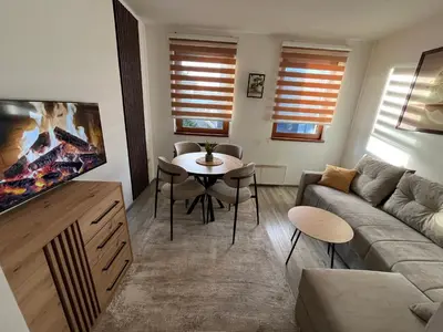 a living room with a couch and a table at Vila Suri Centar in Kopaonik