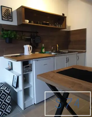 a kitchen with white cabinets and a wooden counter top at Apartments S73&S74 Milmari Resort, Kopaonik in Kopaonik