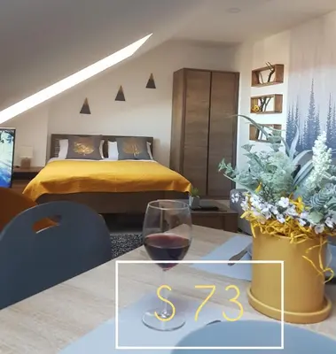 a bedroom with a bed and a glass of wine at Apartments S73&S74 Milmari Resort, Kopaonik in Kopaonik