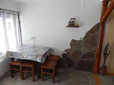 a room with a table and a stone wall at Etno kuca Nikolov in Dimitrovgrad