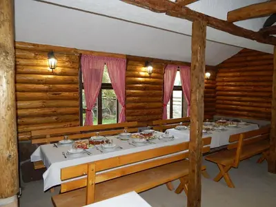 a dining room with a table in a log cabin at Etno kuca Nikolov in Dimitrovgrad