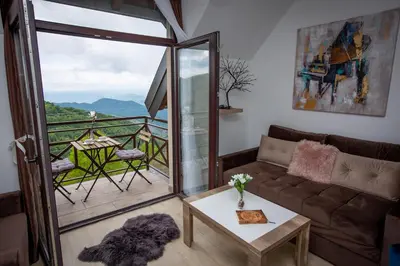 a living room with a couch and a balcony at Apartments View Dvori E25 in Kopaonik