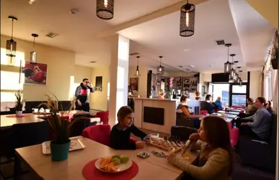 a group of people sitting at a table in a restaurant at Apartments View Dvori E25 in Kopaonik