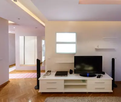 a living room with a tv on a white cabinet at Hotel Crystal - Depandans in Kraljevo