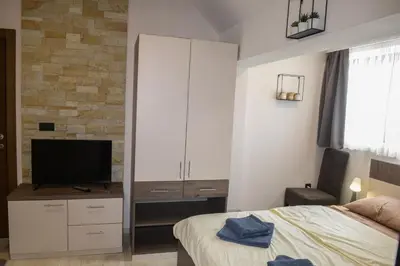 a bedroom with a large white cabinet and a television at Apartman Milmari Idila in Kopaonik