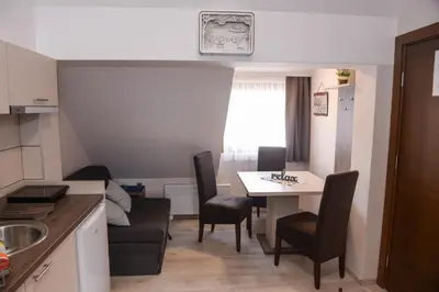 a kitchen and dining room with a table and chairs at Apartman Milmari Idila in Kopaonik