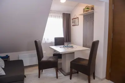 a dining room table and chairs in a room at Apartman Milmari Idila in Kopaonik