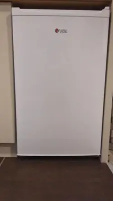 a white refrigerator freezer sitting in a room at Apartman Milmari Idila in Kopaonik