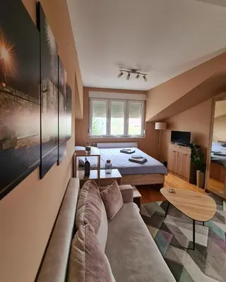 a living room with a couch and a bed at SOGNI D'ORO in Niš