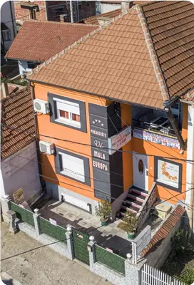 an orange house with a sign on the side of it at Vila Mala Evropa in Leskovac