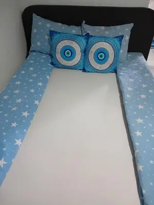 a bed with blue and white pillows and blueuds at Vila Mala Evropa in Leskovac
