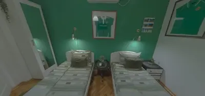 a room with two beds and a green wall at Vila Mala Evropa in Leskovac