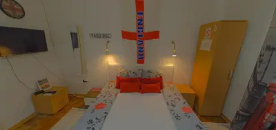 a small room with a bed with orange pillows at Vila Mala Evropa in Leskovac