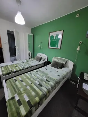 two beds in a room with a green wall at Vila Mala Evropa in Leskovac