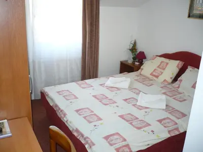 a bedroom with a bed with a white and pink blanket at Motel Stara Vrba in Kuršumlija