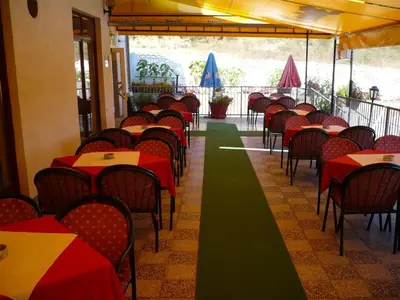 a row of tables and chairs in a restaurant at Motel Stara Vrba in Kuršumlija