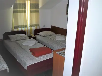a small bedroom with two beds and a mirror at Motel Stara Vrba in Kuršumlija