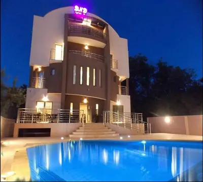 a large building with a swimming pool in front of it at Guesthouse Vila DND in Niška Banja