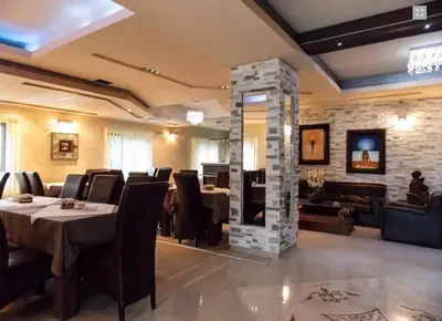 a restaurant with a table and chairs and a fireplace at Guesthouse Vila DND in Niška Banja