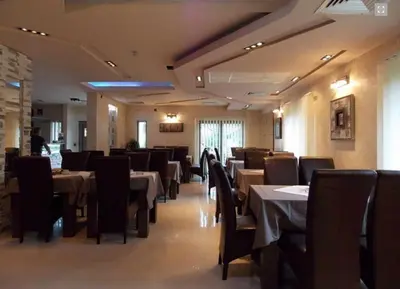 a dining room with tables and chairs in a restaurant at Guesthouse Vila DND in Niška Banja