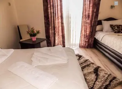 a bedroom with a white bed and a window at Guesthouse Vila DND in Niška Banja